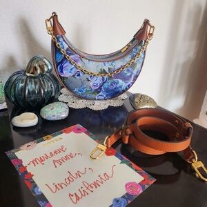 This is a Louis Vuitton Metallic Monogram LV Garden Loop PM bag in blue coated c